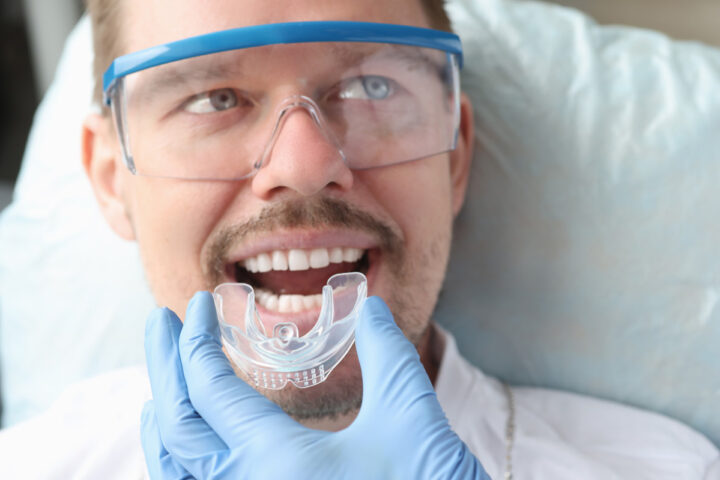 Orthodontist fitting Invisalign aligner in patient