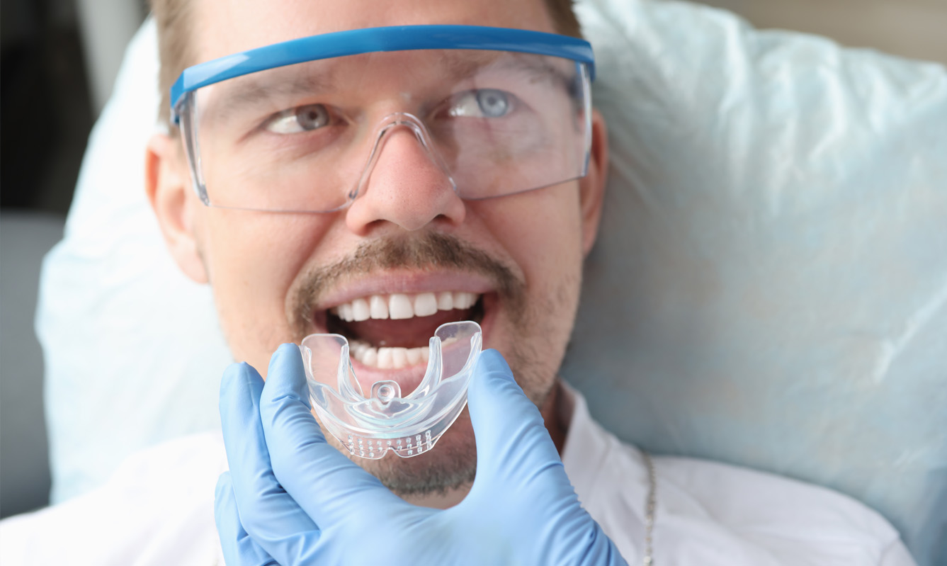 Orthodontist fitting Invisalign aligner in patient